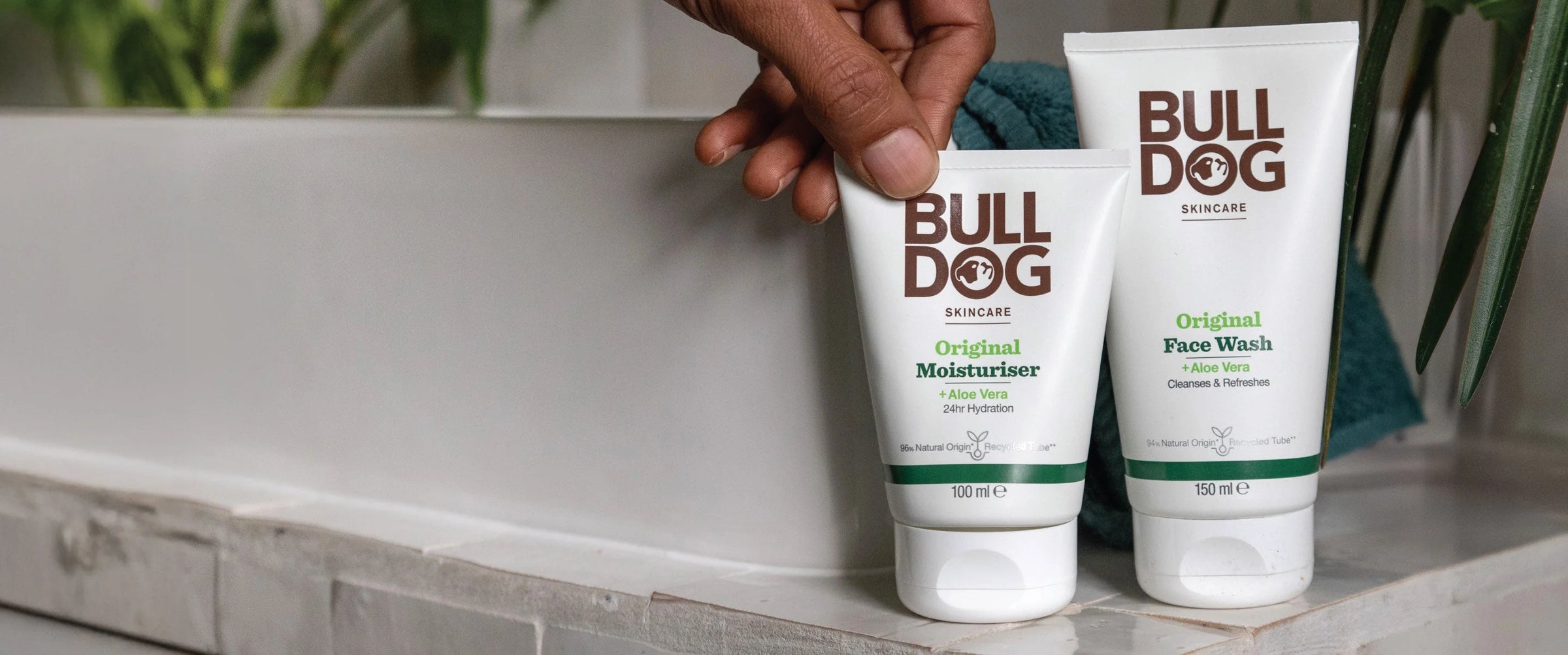Two tubes of Bulldog skincare products on a bathroom counter.
