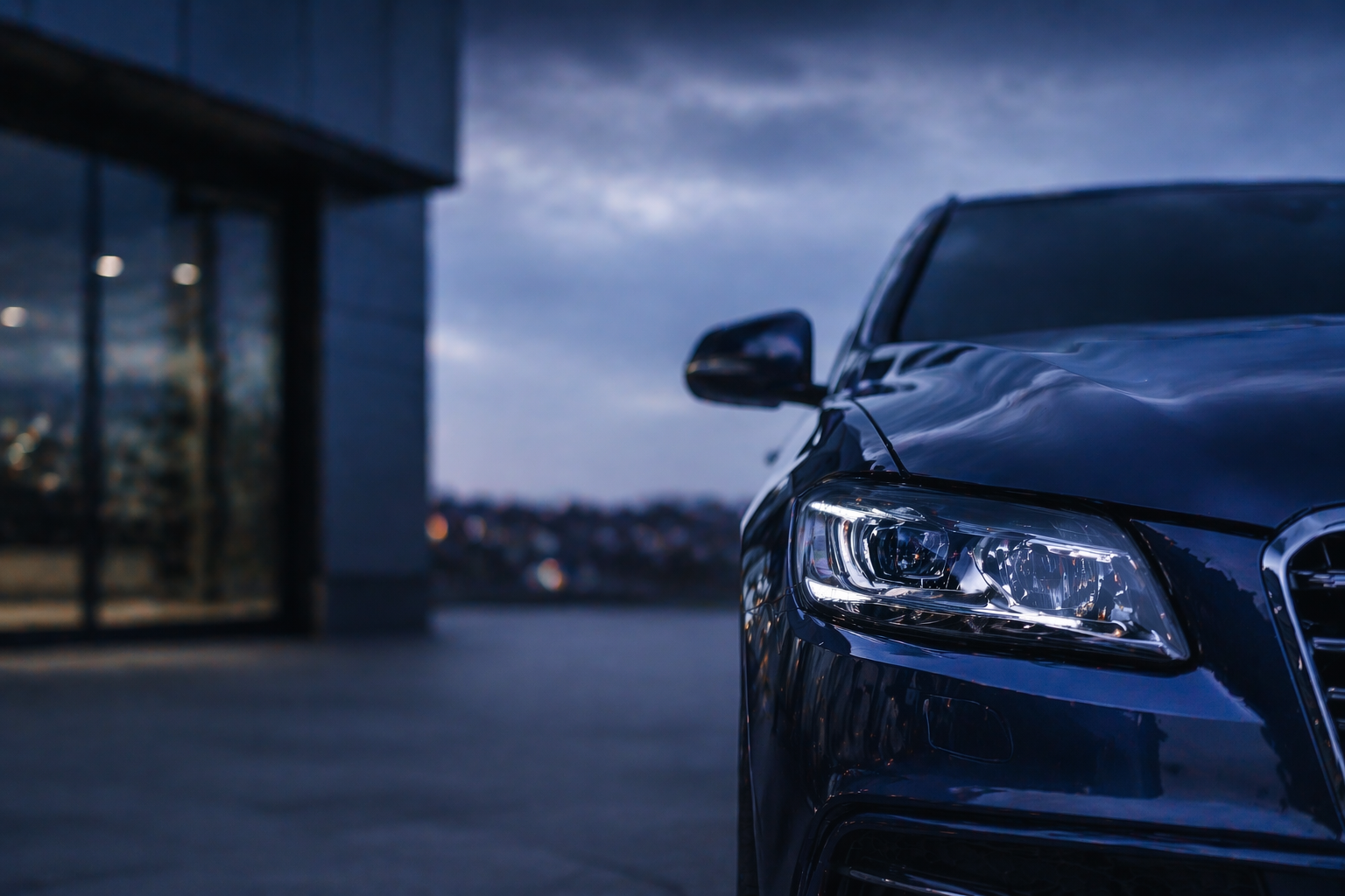 Car headlight on a dark street with a building in the background for My Car Check