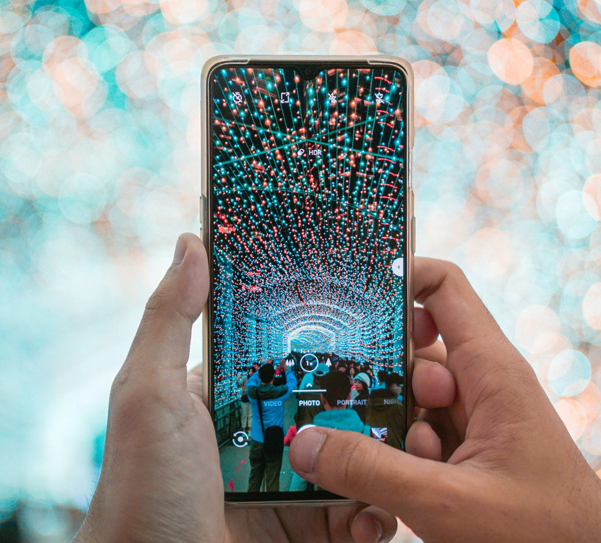 Person holding a smartphone with a colorful display against a blurred background